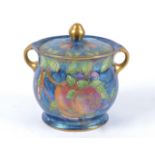 A Maling lustre biscuit barrel, decorated in the 'Plum and Orchard' pattern, heightened in
