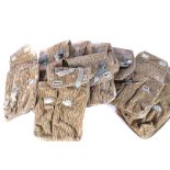 A group of ten East German AK magazine pouches, each having Strichtarn camouflage, opens to reveal