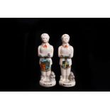 Two Carlton China Great War Munitions Workers, standing holding a shell while standing next to