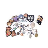 A selection of British metal and cloth badges, including RAF wings, sweetheart brooches, epaulettes,