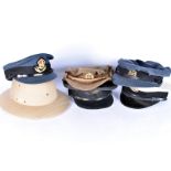 An assortment of six hats, to include three RAF peak caps, an ATS example, a sun helmet plus another