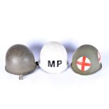 Three American style helmets, one having Medic decals, another painted white with later applied MP