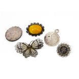 Five silver brooches, including a filigree butterfly, a butterscotch amber with filigree mount, an