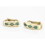 A pair of contemporary continental yellow metal emerald and diamond ear clips, with oval cut