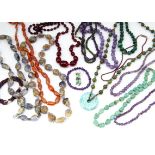 A collection of hardstone jewellery, including a string of cherry amber style knotted beads, of