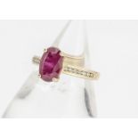 A ruby and diamond 18ct gold dress ring, with oval mixed cut claw set ruby, with brilliant cut