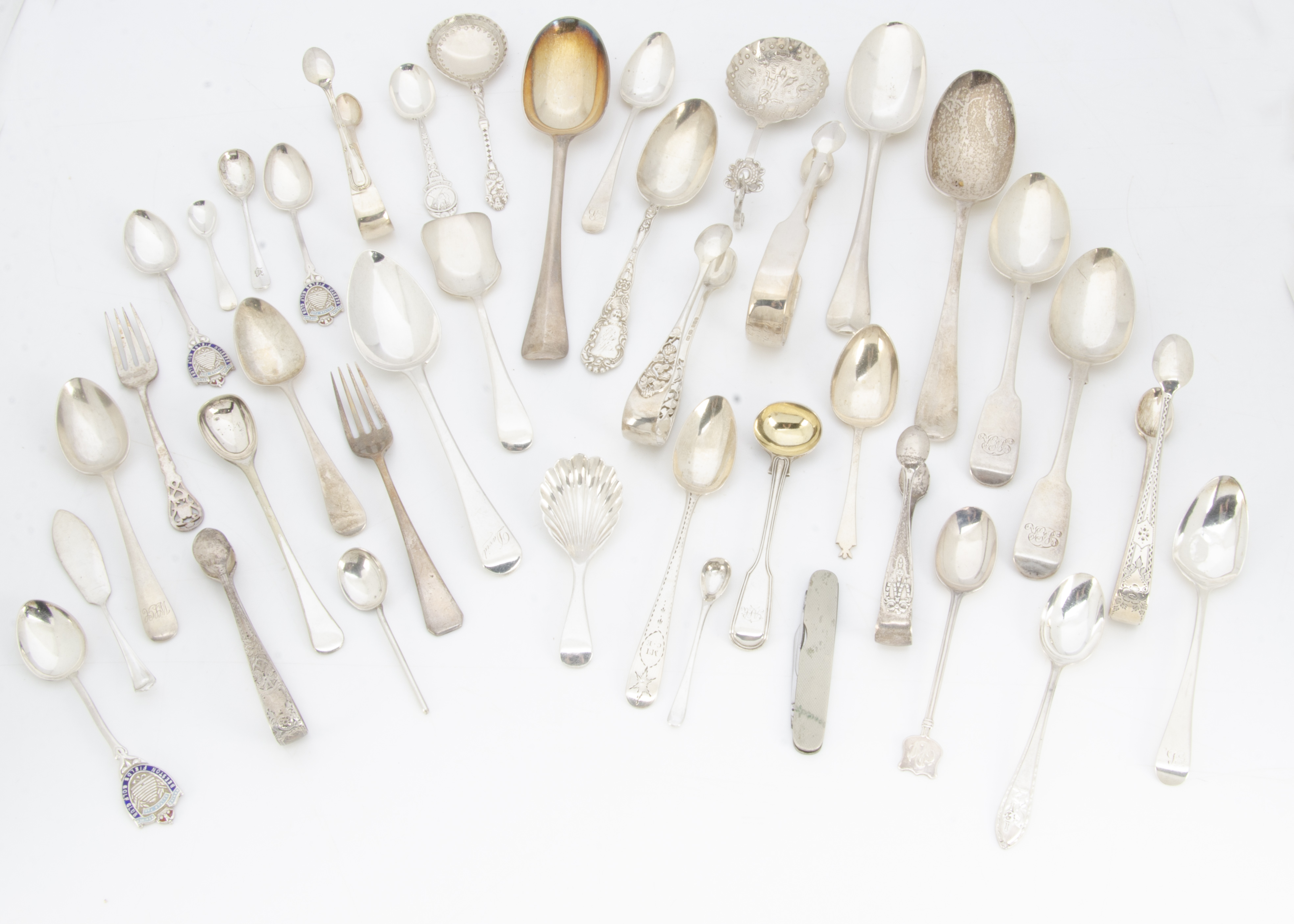 A collection of silver spoons and other flatware, including several tablespoons and dessert