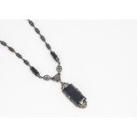 An Art Deco style black glass and marcasite necklace and pendant, the rectangular glass panels in