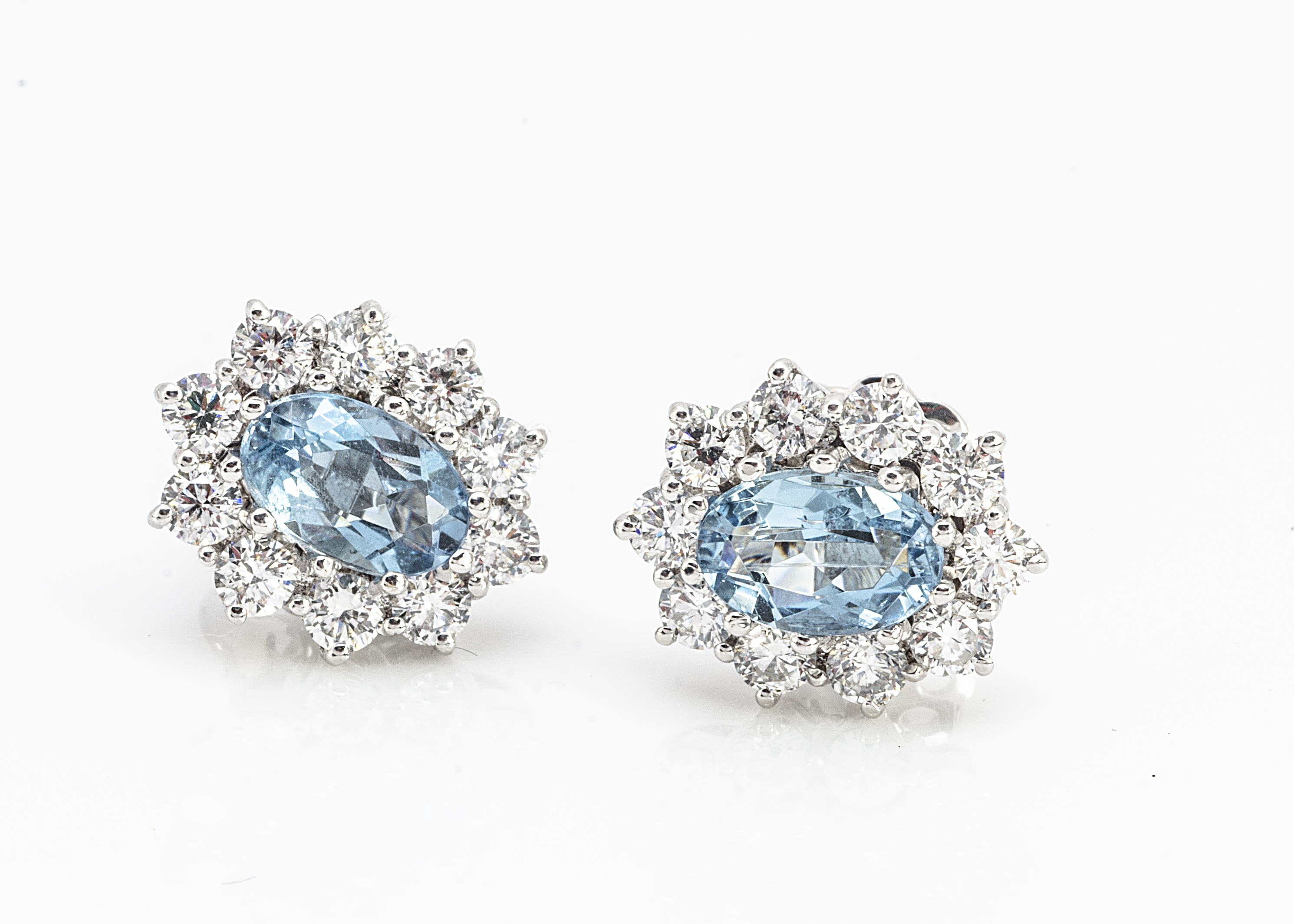 A pair of aquamarine and diamond white 18ct gold cluster ear studs, oval mixed cut central