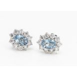 A pair of aquamarine and diamond white 18ct gold cluster ear studs, oval mixed cut central