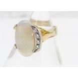 A contemporary white opal and paste stone dress ring, in a crossover style setting with a crescent