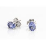 A pair of oval mixed cut tanzanite ear studs set in silver