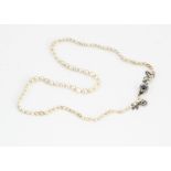 An early 20th Century string of natural knotted pearls, of irregular barrel bouton and oval form, on