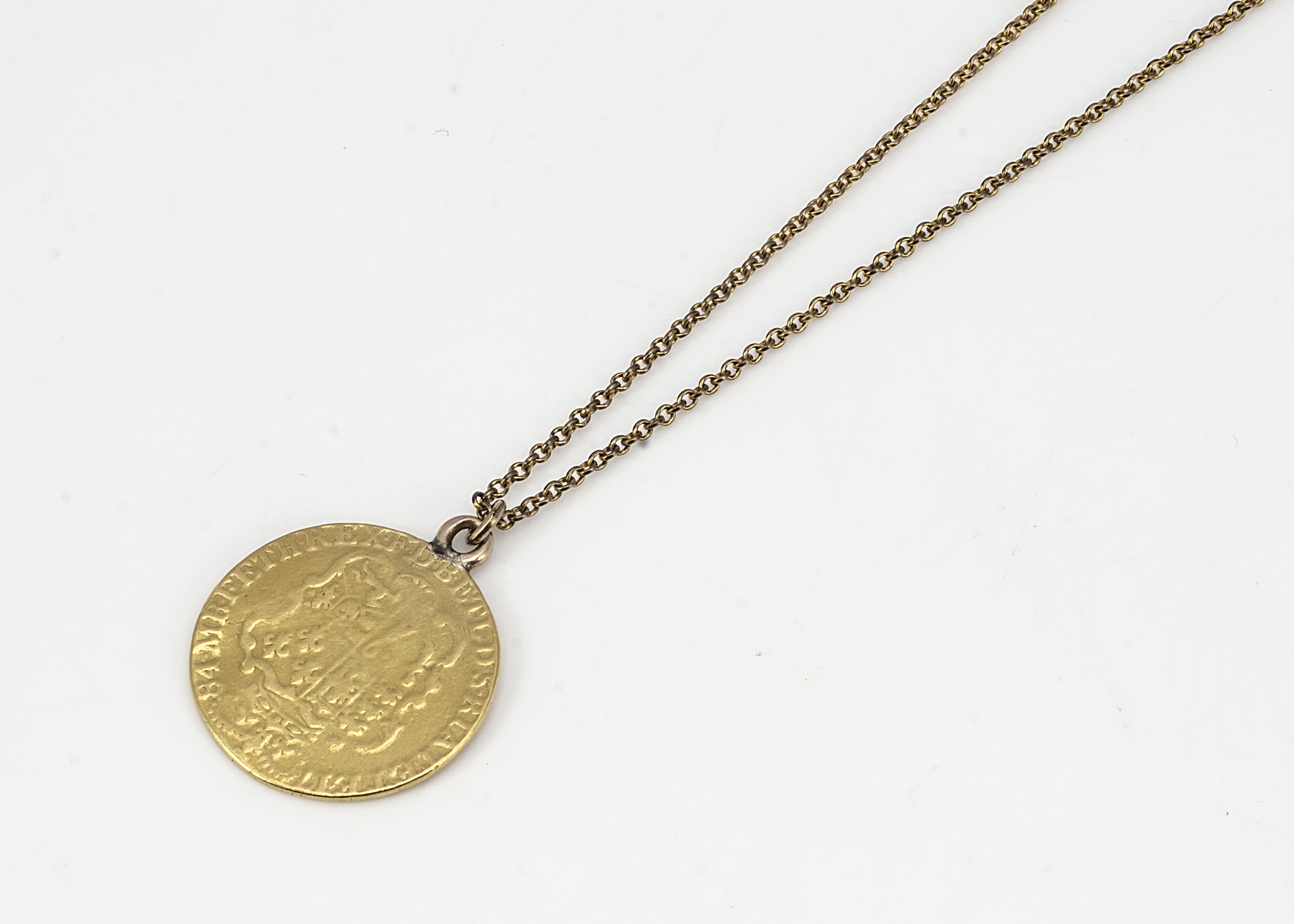 A George III 1784 spade guinea pendant, on a gilt metal chain, pendant 8.5g, 2.4cm diameter