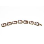 An early 20th Century continental shell carved cameo bracelet, the seven rectangular panels all