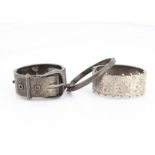 Three silver hinged bangles, one with aesthetic floral decoration, with beaded edges, another of