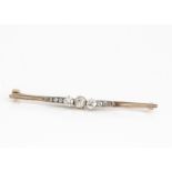 An Edwardian gold and platinum tipped diamond bar brooch, the old cut diamonds in claw setting