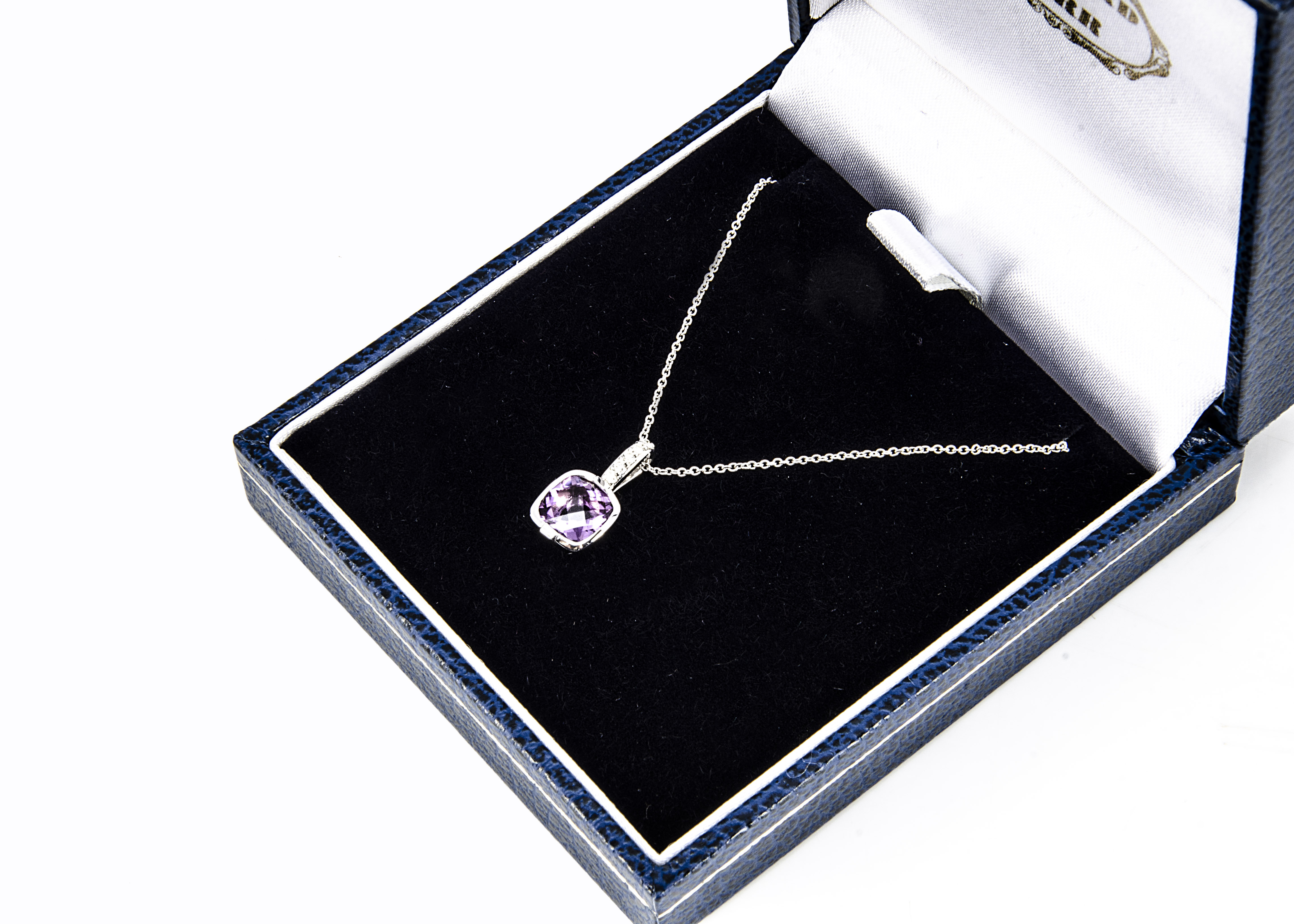 A contemporary 18ct white gold amethyst and diamond pendant, the cushion cut amethyst in enclosed