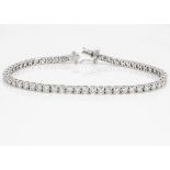 A diamond line bracelet, the brilliant cuts in four claw settings, all in white 18ct gold,