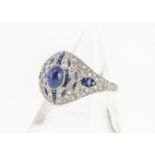 An Art Deco style platinum sapphire and diamond bombe shaped ring, with cabochon sapphire within