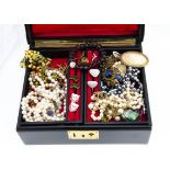 A quantity of costume jewels, including simulated pearls, brooches, bracelets etc in a black leather