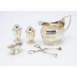 A George III silver helmet shaped milk jug, together with a pair of Victorian silver peppers by