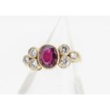 An 18ct gold ruby and diamond contemporary dress ring, the oval ruby in collar setting flanked by