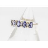 A 9ct gold tanzanite and white sapphire dress ring, the oval claw set tanzanites alternately set