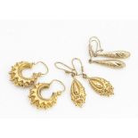 Three pairs of 9ct gold earrings, including two pairs of drops, one with floral decoration, and a