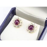 A pair of continental yellow metal ruby and diamond earrings, the cabochon rubies in four claw