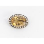 A 9ct gold citrine and pearl bezel oval brooch, the claw set citrine with crown gallery and half