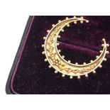A 15ct gold crescent brooch, with floral leaf and berry design with beaded edges marked 15ct, 3.