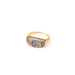 An 18ct gold three stone sapphire and old cut diamond dress ring, the oval mixed cut sapphires
