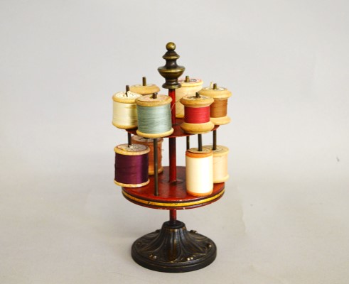 A 19th Century tole ware and cast iron cylindrical cotton reel stand, of two tier section with red