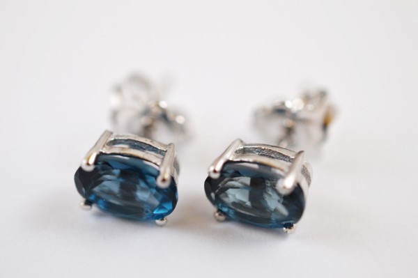 A pair of topaz oval mixed cut ear studs, set in silver, London blue variety