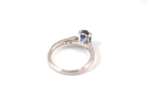 An 18ct white gold sapphire and diamond dress ring, the oval mixed cut claw sapphire in raised - Image 2 of 2