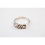 A three stone diamond dress ring, the brilliant cuts in claw setting on a pierced gallery and
