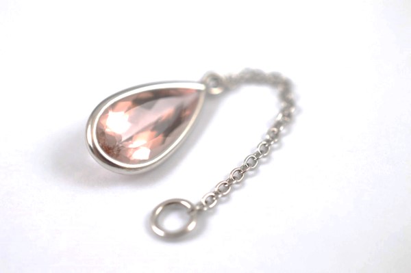 An 18ct gold and morganite drop pendant, the pear shaped beryl within a white metal collar