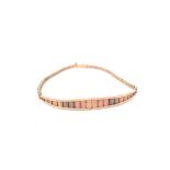 A contemporary three coloured 9ct gold bracelet, the fixed curved ovoid section with textured