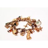 A 9ct gold curb link padlock clasp charm bracelet, with charms including cuckoo clock, kettle,