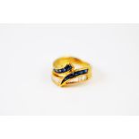 A continental 18k yellow metal sapphire and diamond dress ring, the baguette set diamonds within