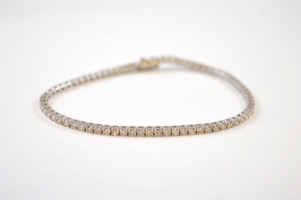 A diamond 18ct gold tennis bracelet, the brilliant cuts in claw setting, 18cm long, total diamond