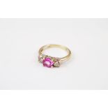 A contemporary continental three stone pink sapphire and diamond dress ring, centred with a circular