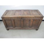 An antique elm four panelled coffer, candle box to interior, carved frieze dated 1692, 134cm x