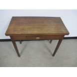 An antique oak tea table, rear single gate leg action, fold over top, central frieze drawer,