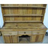 A wax pine dresser of 19th Century origin, the back having three selves flanked by turned columns,