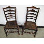 A pair of 19th Century ladder back chairs, shaped back splats, elm seats and a turned front