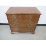 An antique walnut chest, of two short over three long drawers, cross banded top, solid sides, top