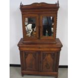 A 19th Century walnut continental two part cabinet, with mirrored door upper section opens to reveal