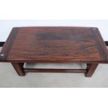 A hardwood low occasional table, raised on square supports, 100cm x 50cm x 41cm